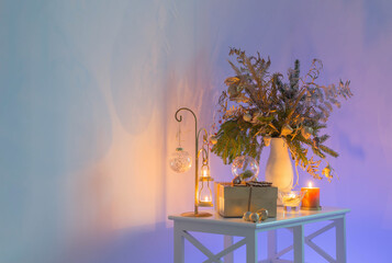 christmas bouquet with burning candles  on background color wall  at the evening