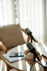 Professional microphones on table of podcaster in studio