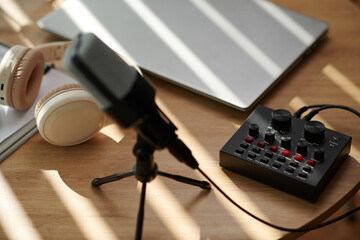 Amplifier, microphone and laptop on table of blogger or podcaster