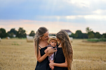 Mom and two daughters in the park. Mom takes care of her two daughters. Mothers Day