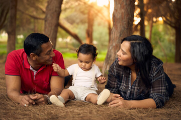 A beautiful family in a park with a one-year-old child