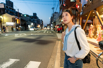 asian korean girl traveler looking for traffic on street while waiting to walk across zebra...
