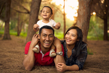 A beautiful family in a park with a one-year-old child