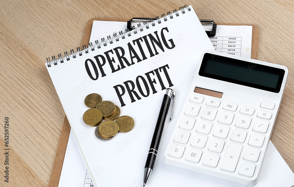 Poster operating profit text on a notebook with chart and calculator and coins, business concept