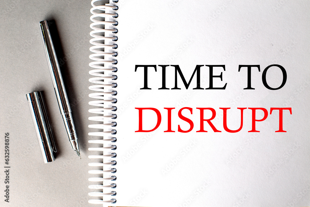 Poster time to disrupt text on a notebook with pen on grey background