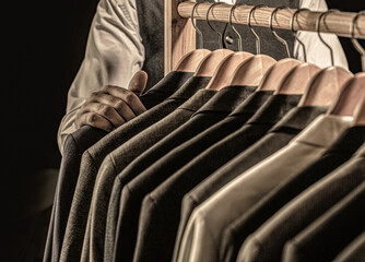 Stylish men's suit. Male suits hanging in a row. Men clothing, boutiques. Man suit, tailor in his workshop