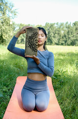 Close up portrait of asian young woman with sadhu board at a half of face. Female asian portrait with closed eyes.