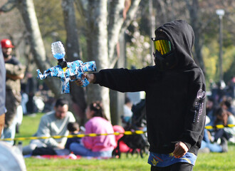 a boy with a mask playing with an airsoft