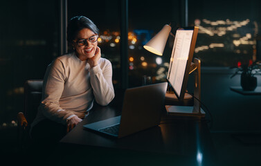 Happy female entrepreneur having a virtual business meeting at night