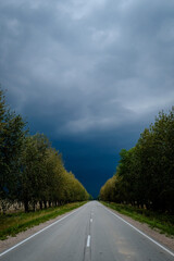 A lonely road in the summer before a threatening storm. Storm in summer. thunder clouds.