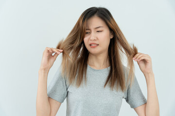Asian woman very sad and upset looking at damaged hair, hair loss, hair thinning problem, vitamin...