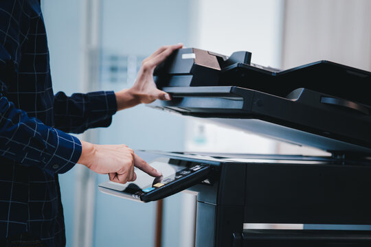 Copier printer, Close up hand office man press copy button on panel to using the copier or photocopier machine for scanning document printing a sheet paper.