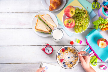 Healthy nutritious  morning breakfast for school kids, with fresh fruits, vegetables, croissant, muesli, milk and sandwich. Child girl having breakfast before school and work, copy space