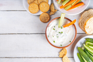 Cottage cheese high-protein dip with fresh vegetables, bread and crackers on wooden white table copy space. Eating diet healthy curd cheese spread with various snacks