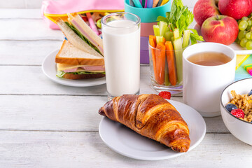 Healthy nutritious  morning breakfast for school kids, with fresh fruits, vegetables, croissant,...