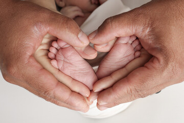 Little feet of a newborn in the hands of mom and dad. Feet of a tiny newborn on parental...