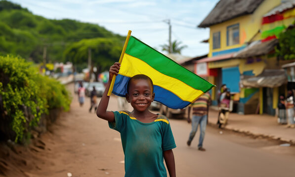 Un gar&ccedil;on gabonais tenait un drapeau de la r&eacute;publique du Gabon dans sa main, dans une rue de Libreville