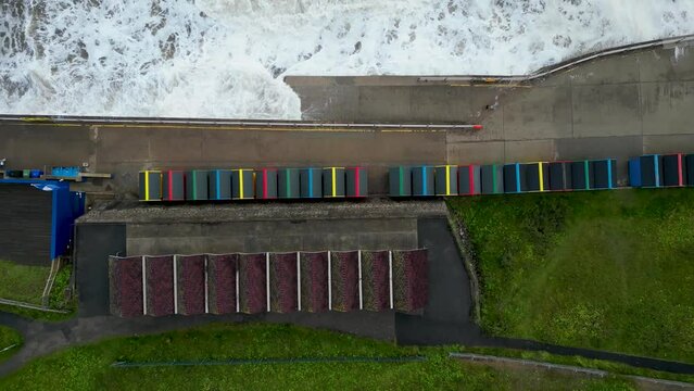4k drone footage of the colourful beach huts along the sea front in Whitby, North Yorkshire, UK