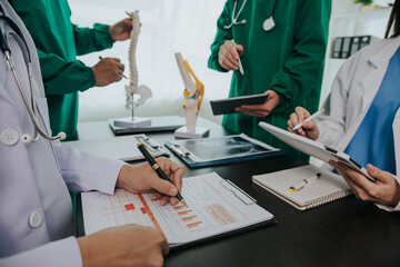 Team of doctors at a medical meeting Close-up of doctor in surgical suit using touchpad or laptop computer