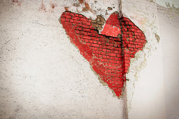 Red heart graffiti on a white brick wall in white plaster made in the opening in the concrete
