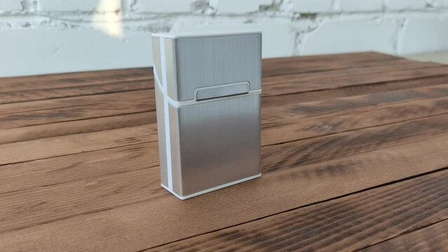 Metal cigarette case on wooden background