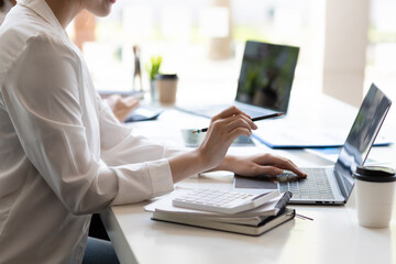 Fototapeta premium Colleagues work on paperwork on their desks. Businesswoman discussing business project project documents in office.