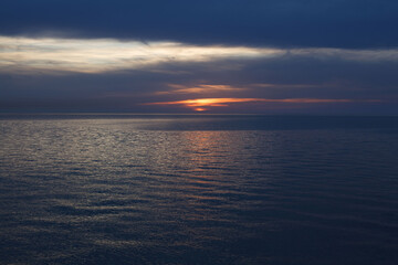 Obraz premium Sunset and sea. Evening landscape of blue cloudy sky and dark sea