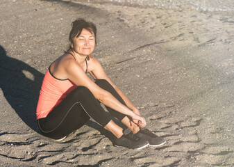 Happy and satisfied woman after sports enjoy morning sunlight on the sea. Active recreation and...