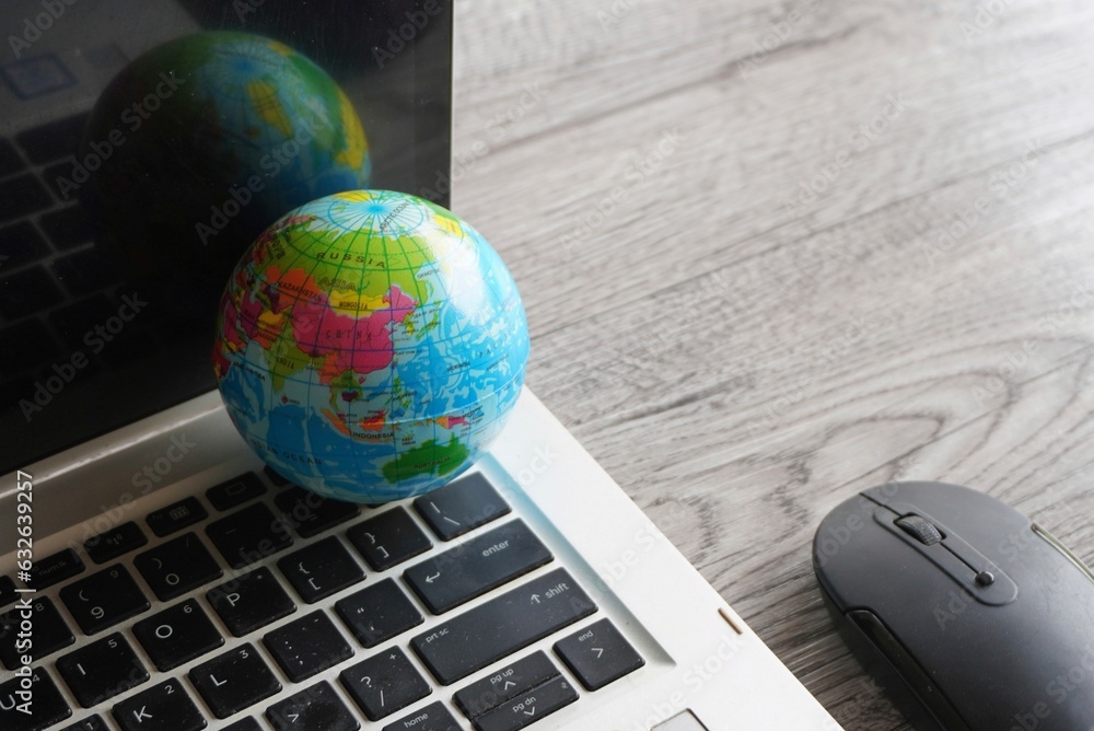Wall mural close up image of globe, laptop keyboard and computer mouse. internet, globalization and technology 