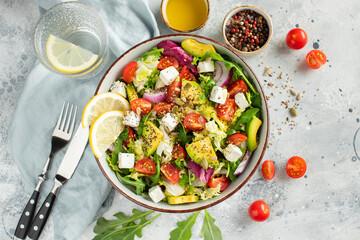 Delicious and healthy green salad of different leaves and vegetables with seeds and olive oil.