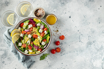 Delicious and healthy green salad of different leaves and vegetables with seeds and olive oil.