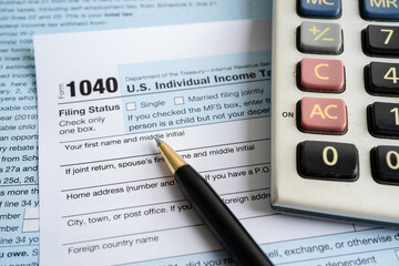 Tax Return form Individual Income with calculator and pen.