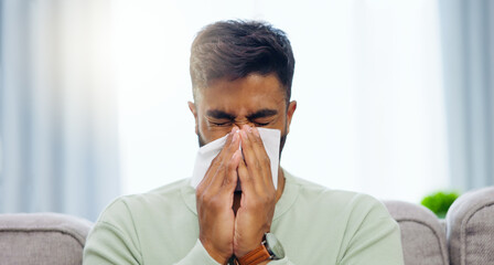 Tissue, sneeze and Indian man blowing nose on a home living room sofa feeling sick and tired....