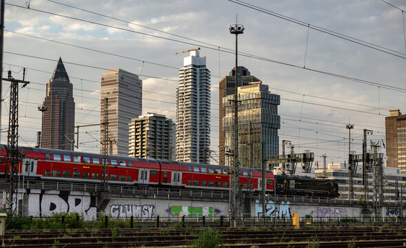 Local passenger train arives in Frankfurt, Germany - July 19, 2023: Signaling systems, railroad ties and switches. Buildings, skyscrapers in the background.