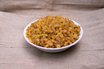 A Bowl of Delicious sweet raisins on the Jute fiber fabric