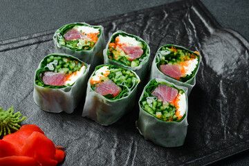 sushi rolls with kale, tuna and avocado. Served with wasabi sauce and pickled ginger. Close up.