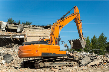 The excavator eliminates the consequences of an earthquake, clearing rubble from residential buildings.