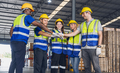 Multinational groups of workers working together wearing uniforms, helmets, shaking hands together, working together to complete the work in  a warehouse at Automotives Part Warehouse