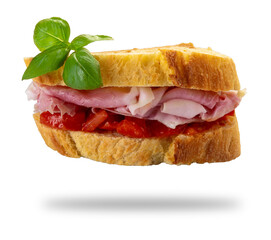 Ham and tomato sandwich between two slices of durum wheat semolina bread with basil leaves, isolated