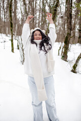 Fototapeta na wymiar Beautiful woman wearing the white sweater, jeans and hat, the girl in warm cothes. Plus size woman waking, have fun in snow day