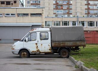 An old rusty awning truck is standing in the yard, Podvoysky Street, Saint Petersburg, Russia, August 8, 2023