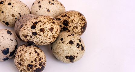 Small quail eggs on white background. Eco products. Horizontal format.