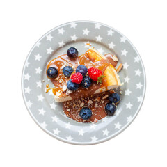 Slice of vanilla cheesecake with salted caramel sauce, fresh raspberry and blueberry on the plate. Isolated on white background, png