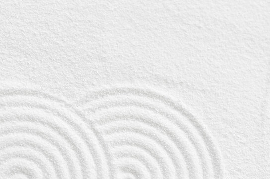 Sand texture with simple spiritual patterns,Japanese Zen Garden with concentric circles and parallel lines on  white sandy surface background,Harmony,Meditation,Zen like concept