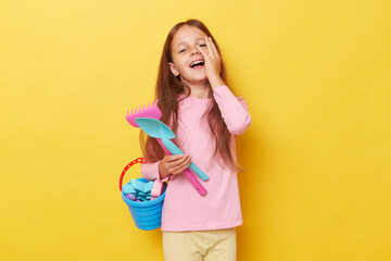 Childhood sandbox joy. Springtime play kit. Happy funny little cute girl with dark hair holding...
