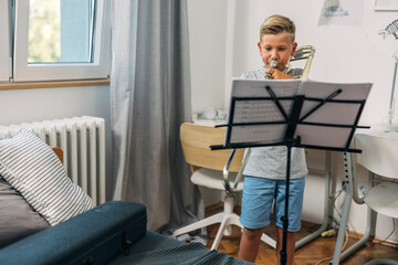 Boy practicing trombone at home.
