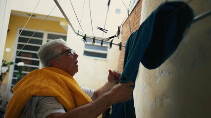 Senior Citizen Tending to Laundry in Backyard, etired Individual Handling Towels in Suburban residence, domestic lifestyle