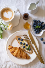 Romantic french breakfast with croissant, blueberries and latte coffee