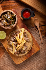 Beef steak taco with french fries. very popular taco in mexico called taco de bistec or carne asada, homemade roast beef served on a corn tortilla. mexican street food.