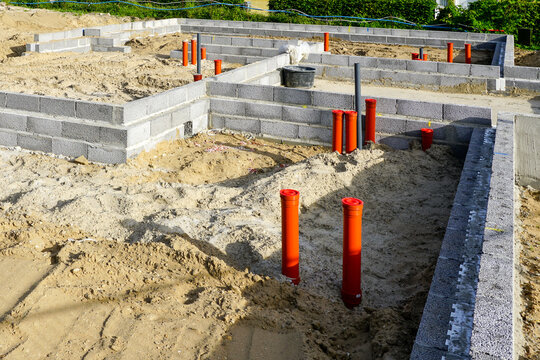 Building the foundation of the house from concrete blocks and installation of pipework system